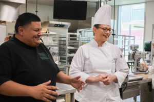 Chefs Adrian Torres and Andrea Huerta talking in San Jac's culinary arts program kitchen
