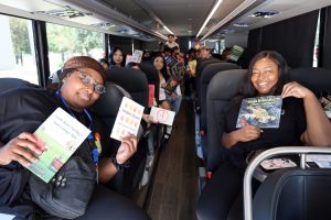 Professors and students on charter bus for Magic Book Bus literary field trip