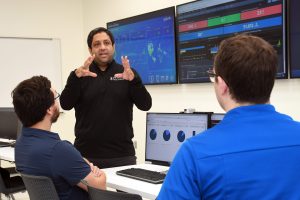 Cybersecurity director and students learning inside Security Operations Center