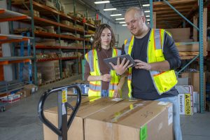 Two workers reviewing warehouse inventory